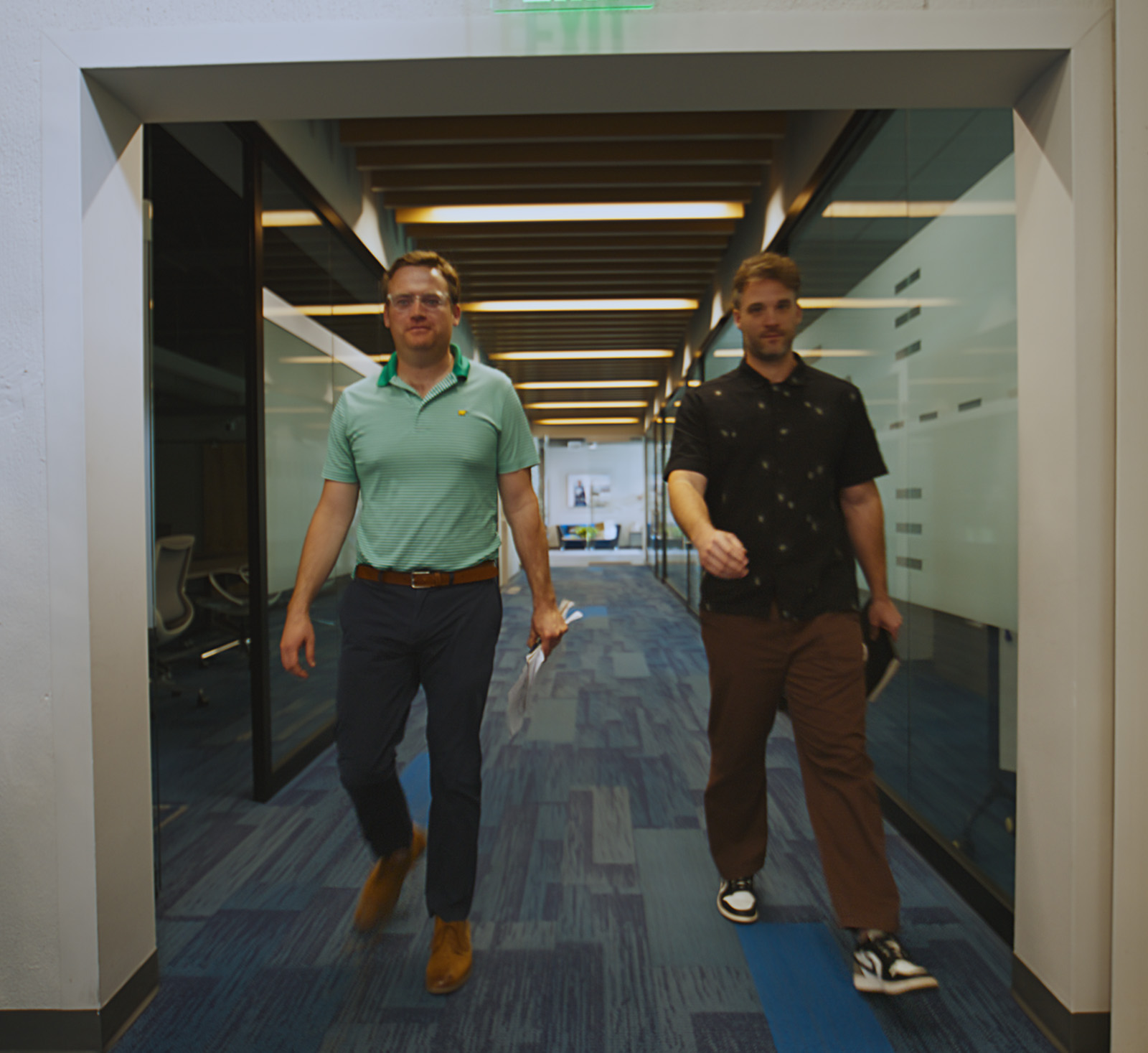 Two people walking through a hallway